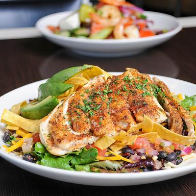 Blackened chicken served with avocado, tortilla strips, black beans  and cheese