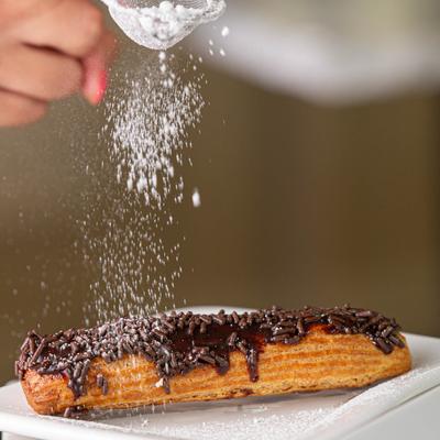 Chocolate sprinkled fried dough pastry, dusted with powdered sugar
