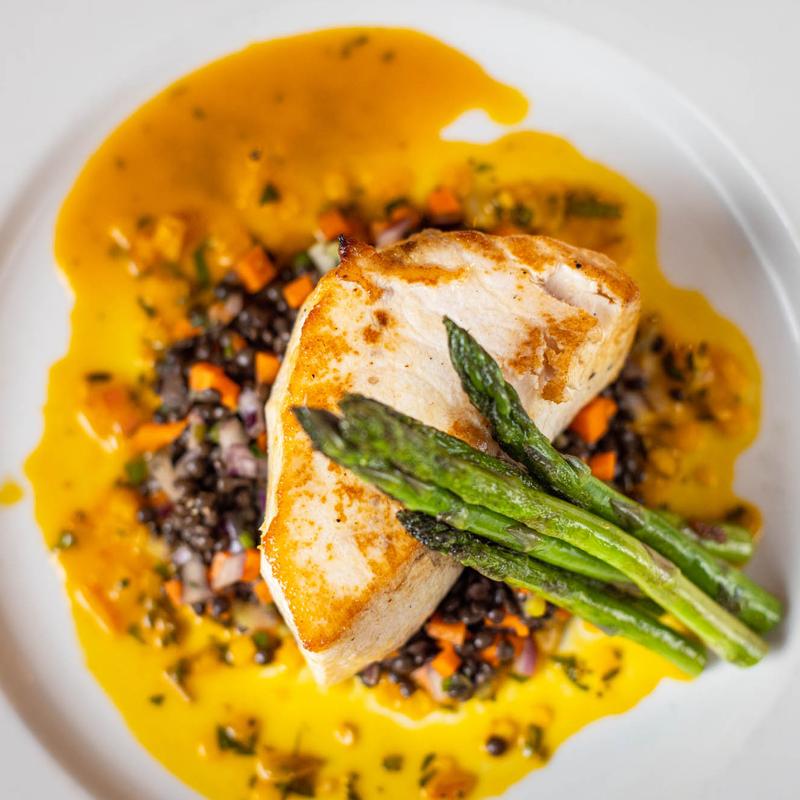 Swordfish filet and asparagus served over mixed lentils and vegetables
