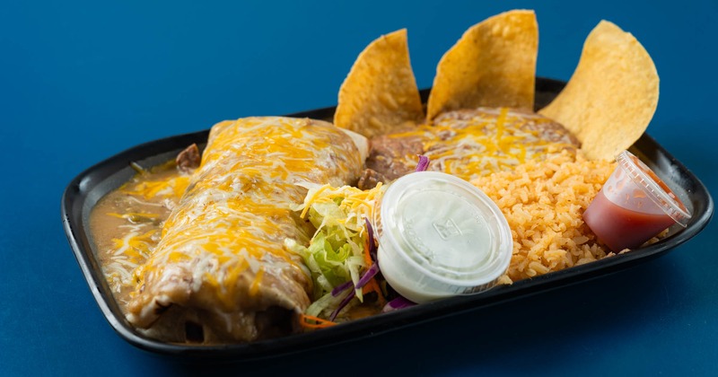 Burrito smothered in cheese, served with rice, beans, chips, and salad