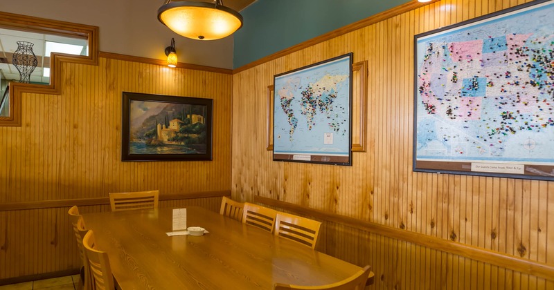 Inside, wood wall paneling, table with chairs, pictures on the walls