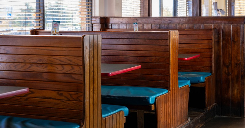 Interior, seating area by the windows, classic wooden seating booths with tables
