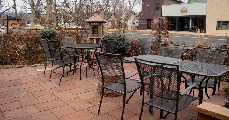 Outside, metal tables and chairs in the patio