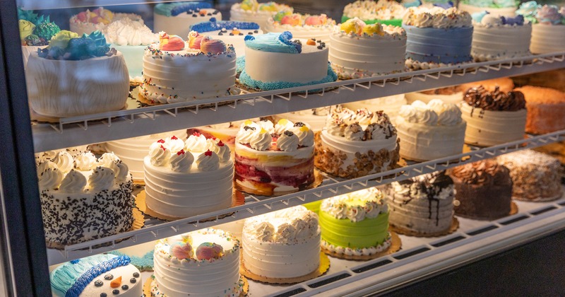 Assorted cakes displayed in a glass case
