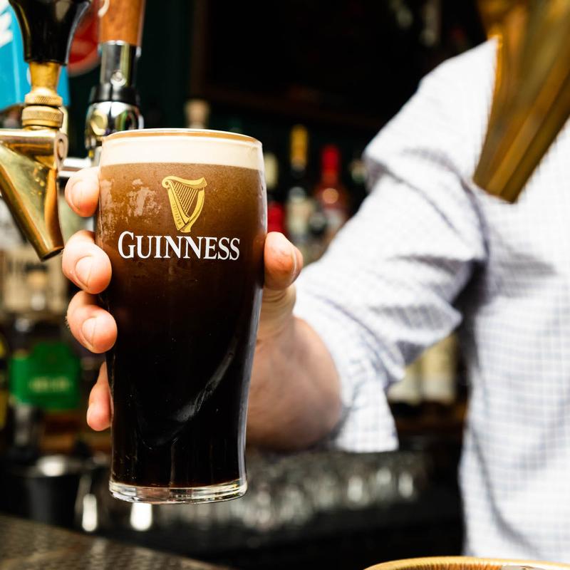 Bartender handing out a glass of Guinness