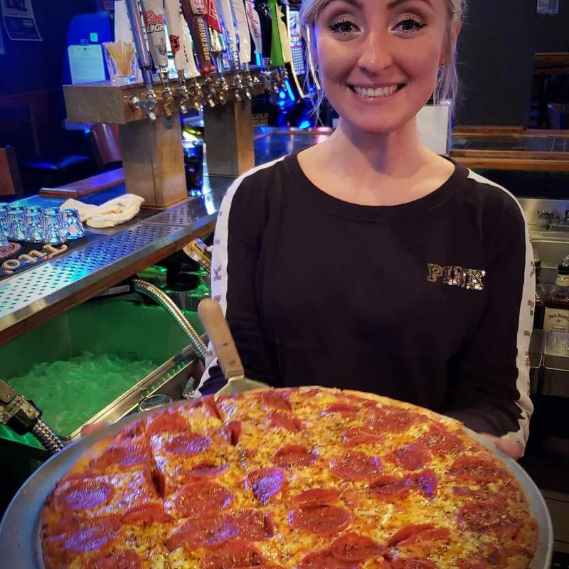 Staff member serving pizza