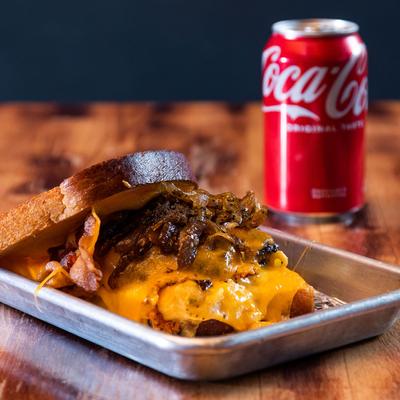 Burger with toasted bread, melted cheddar, mac and cheese, crispy bacon