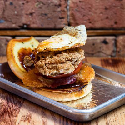 Early Bird burger with fried egg, chicken, hash brown, bacon, tomato and pepper jam