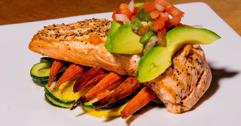 Grilled salmon, on a bed of roasted carrots and zucchini, topped with salsa