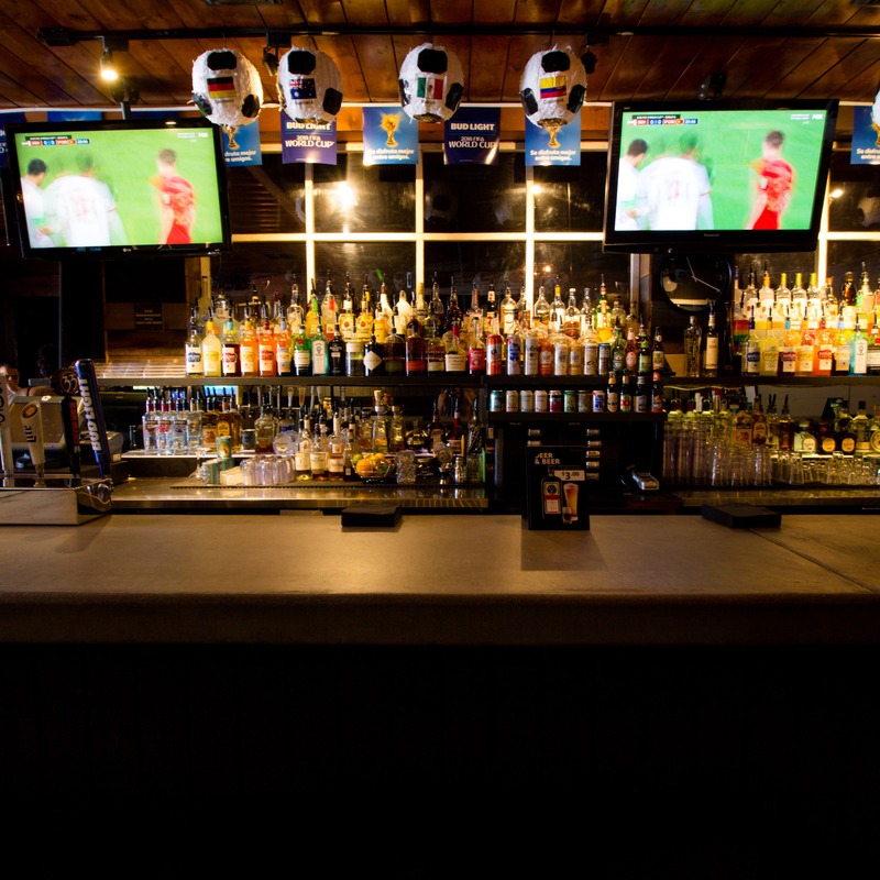 Interior, bar with decorations and a lot of liquor, beer taps and tv screens