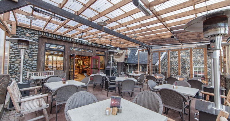 Exterior, partially covered seating area, outdoor heaters, restaurant entrance