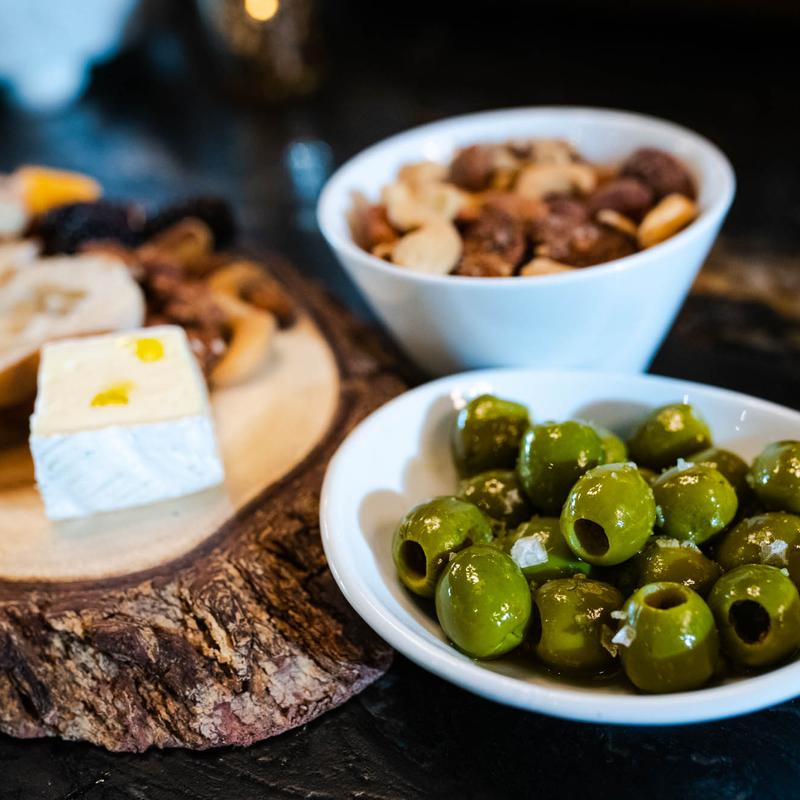 Cheese platter with a side of green olives and nuts