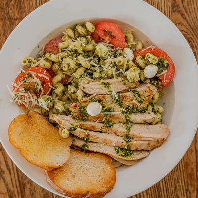 Pesto Caprese Pasta with grilled chicken and toast bread, top view