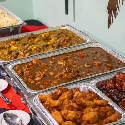 Buffet set up with several trays of warm food presenteed on the table.