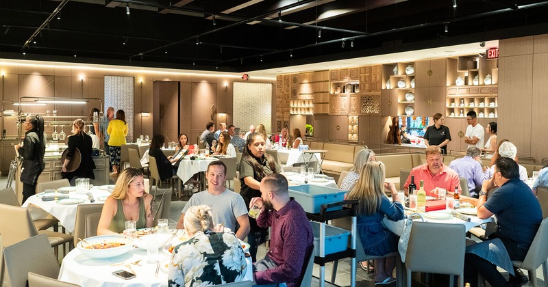 Restaurant interior, dining area, guests chatting and enjoying their food and drinks