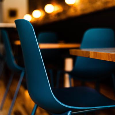Empty dining tables with blue chairs, close-up.