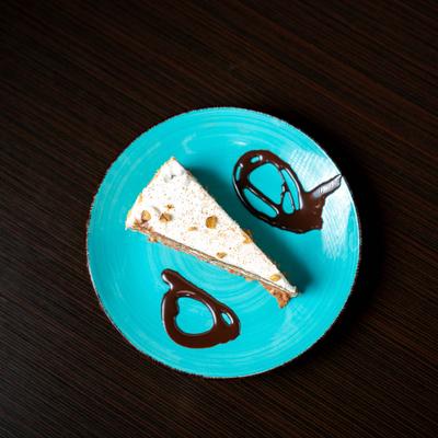 Vegan carrot cake on a blue plate drizzled with chocolate syrup.