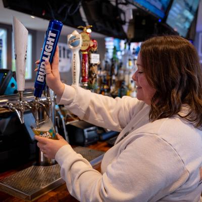 A bartender pouring tap beer.