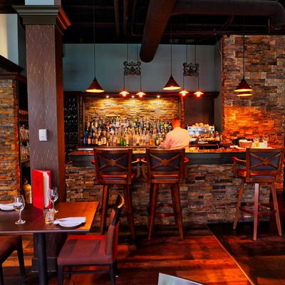 Stone bar with elegant stools and pendant lights.