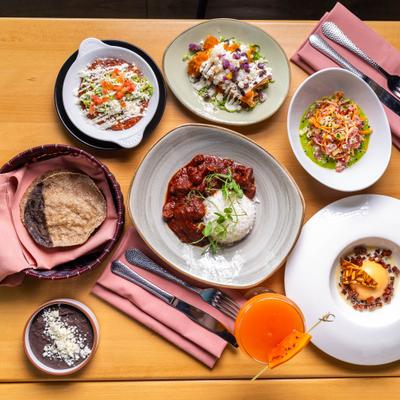 Vibrant Mexican food spread with stewed pork, handmade tortillas, black beans, and fresh salads.