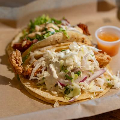 Fish taco served with a small salsa cup.