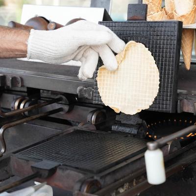 An employee baking an ice cream cone.