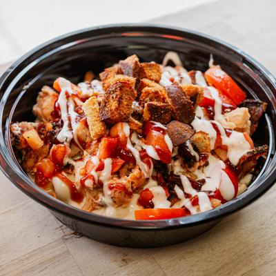 Chicken Bacon Mac Bowl with bacon, diced tomatoes, sweet BBQ, buttermilk ranch and pretzel crouton.