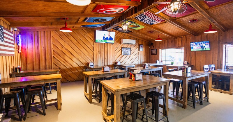 Diner area, tables and chairs, tv screen above