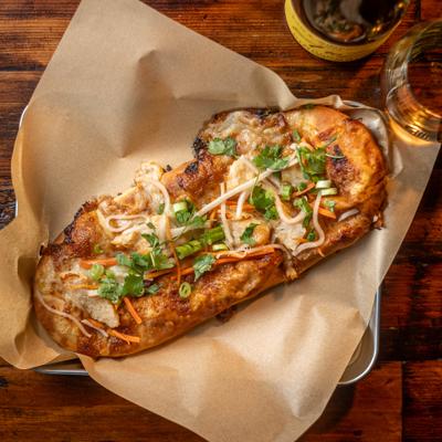 Flatbread pizza topped with cheese and herbs.