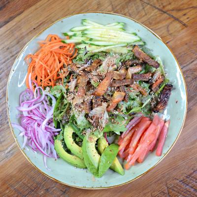 A colorful salad with assorted vegetables and grilled meat, top view.