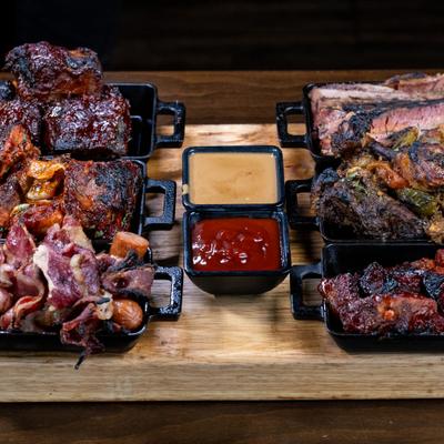 Meat Lovers BBQ Platter served on the wooden board with two sauces.