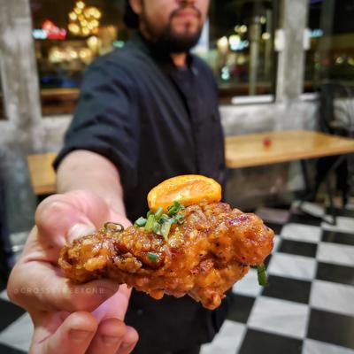 Delicious chicken wing being held up for a photo small