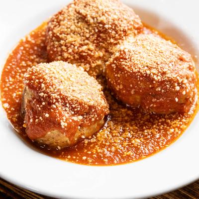 Meatballs in tomato sauce, with sprinkled cheese.