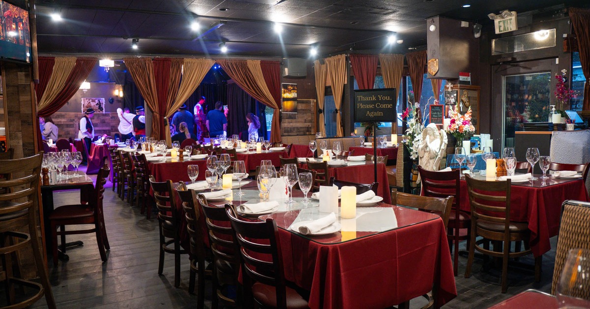 Interior, dining area, tables and chairs ready for guests, stage in the back