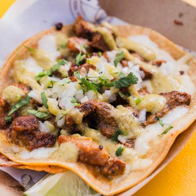 Carne Asada Taco served in a cardboard boat, close-up.