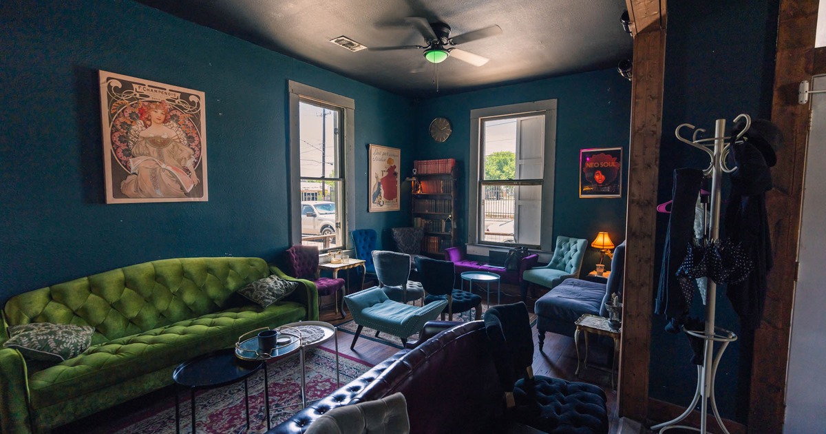 Cozy room with eclectic furniture, including a green sofa and colorful chairs