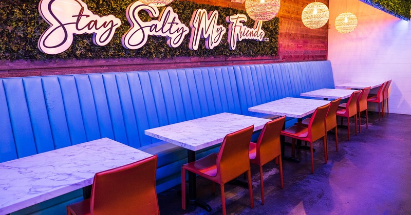 Interior, upholstered benches, lights, marble tables, chairs, windows