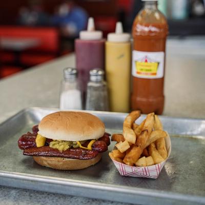 double meat hotdog  split on hamburger bun and french fries.