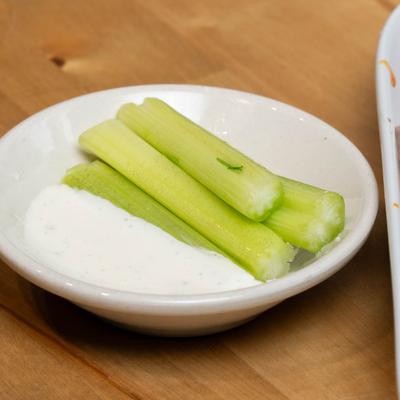 Celery and sauce for chicken wings, close up.