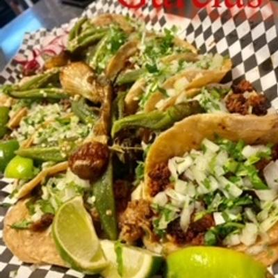 Tacos topped with fresh cilantro and diced onions.