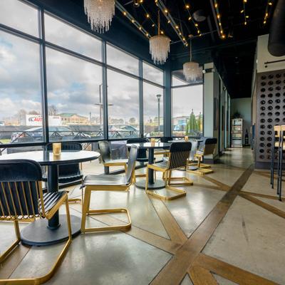 Interior, tables and seats by window side with chandeliers on the ceiling