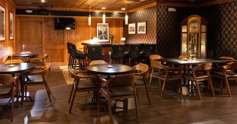 A warmly lit interior with wooden tables and chairs