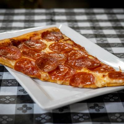A slice of pepperoni pizza on a white plate.