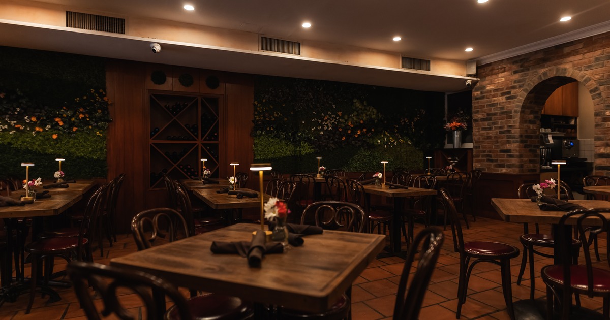 Restaurant dining room with wooden tables and green wall decor