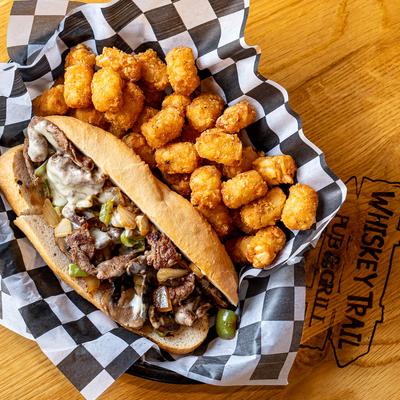 Philly sandwich with a side of tater tots.