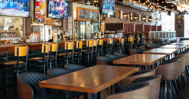 Interior - a long bar, high stools, decorative wall elements with multiple TVs .