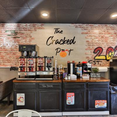 Self-service counter area with a mural on a brick wall.