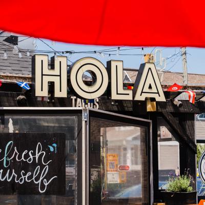 Storefront featuring restaurant signage and string lights.