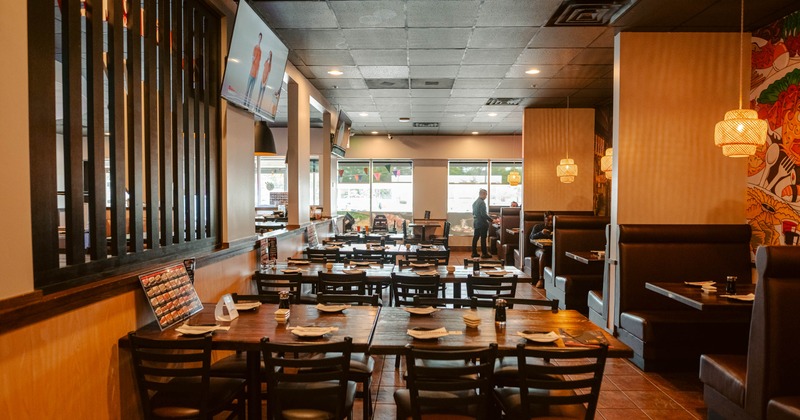 Restaurant dining room with dark booths and wooden tables