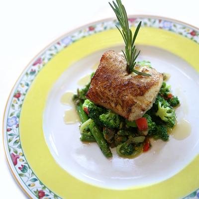 Baked Pacific sea bass served with vegetables.